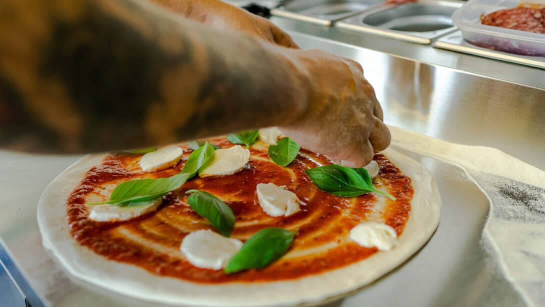 A person making a pizza.