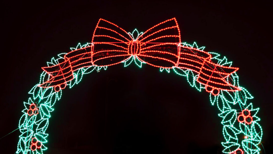 A lit up Christmas wreath light display