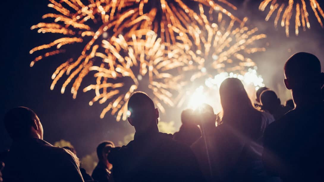 Fireworks going off above a group of people.