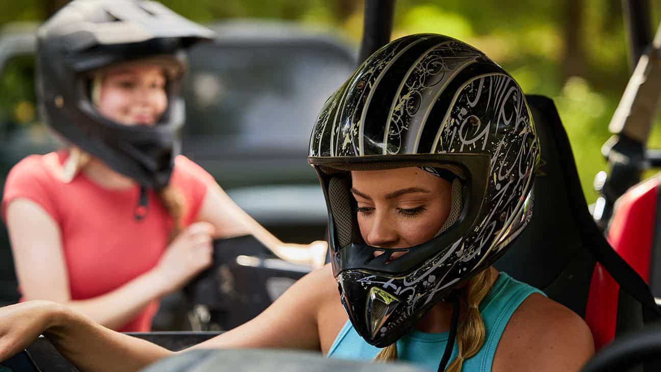 Four men are smiling and drinking beer in a brewery.