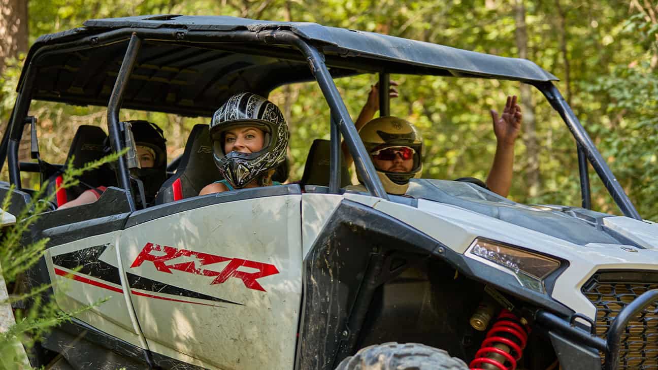 Four men are smiling and drinking beer in a brewery.