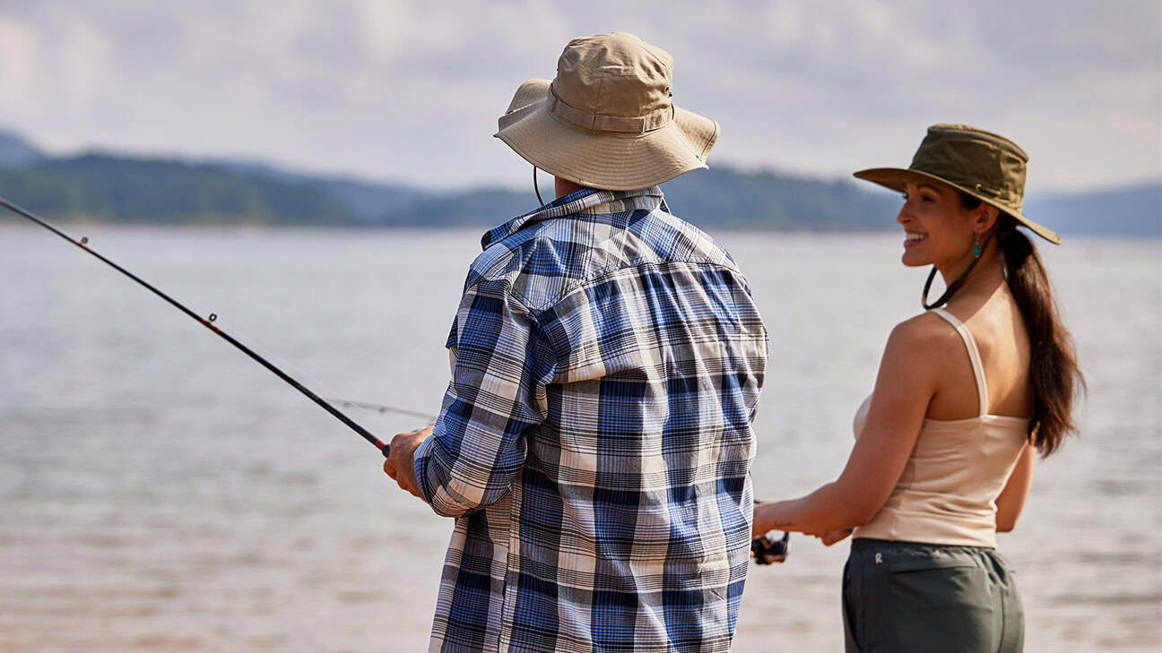 A couple fishing at a lake.