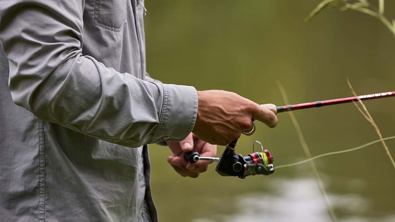 A person reeling in a fishing pole.