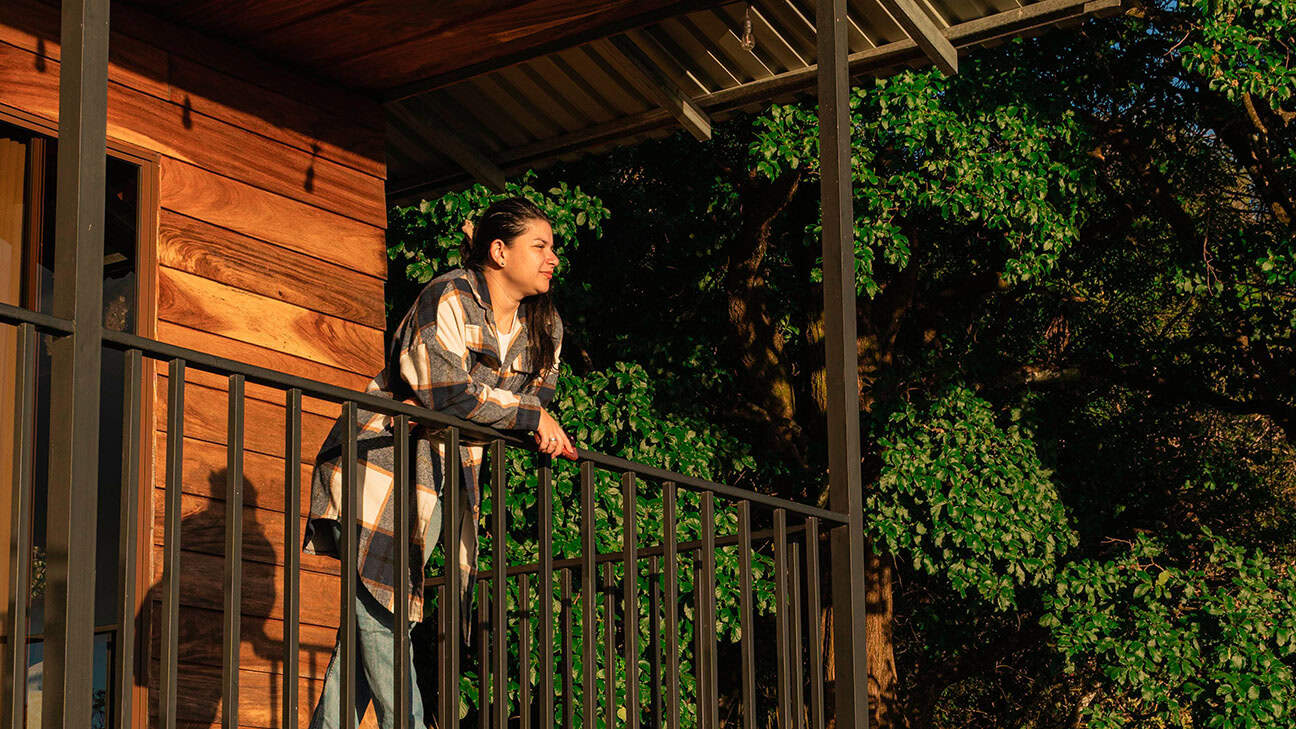 A woman sitting outside looking into a view.